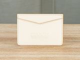 a white card case sitting on top of a wooden table