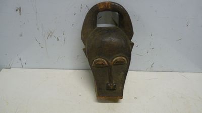 un masque en bois accroché au mur d'une pièce