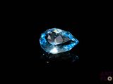 a close up of a blue diamond on a black surface