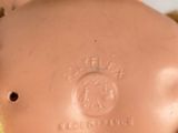 a close up of a doll with a teddy bear on it ' s chest