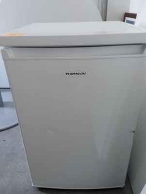 a small white refrigerator in the corner of a room