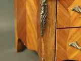 a small wooden chest of drawers with a marble top