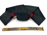 a black hat and a knife on a white surface