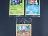 trois cartes pokemon posées les unes sur les autres sur une table
