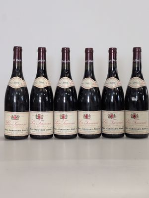 six bouteilles de vin sont alignées sur une table