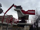 une grue rouge perchée au sommet d'un immeuble