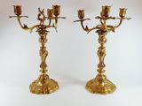 pair of antique brass candelabs with flowers on each of them