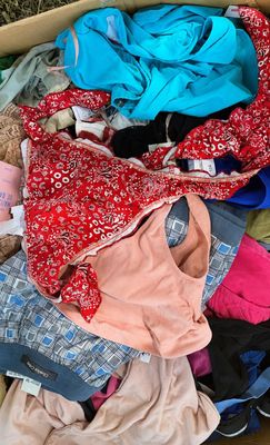 une boîte remplie de vêtements posée par terre
