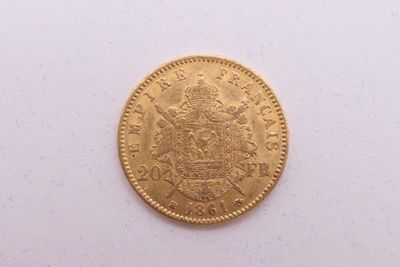 gros plan d'une pièce d'or sur une surface blanche