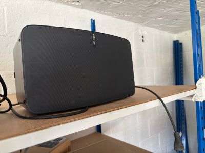 une enceinte noire posée sur une étagère dans une pièce