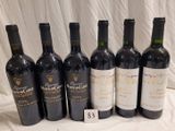 several bottles of wine are lined up on a table