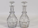 pair of clear glass decanters sitting on a white surface