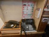 two telephones on a shelf in a small room