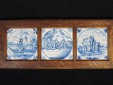 trois carreaux bleus et blancs représentant un homme et une femme dans un bateau
