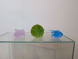 a glass table with three different colored figurines on top of it