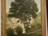 tableau représentant un arbre et une rivière, dans un cadre doré, accroché au mur
