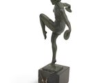 statue of a woman kicking a soccer ball on a marble base