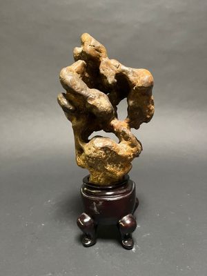 an image of a sculpture of two hands holding a rock