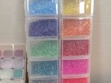 a lot of different colored beads in the bins