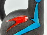 a black vase with a blue and red design on it