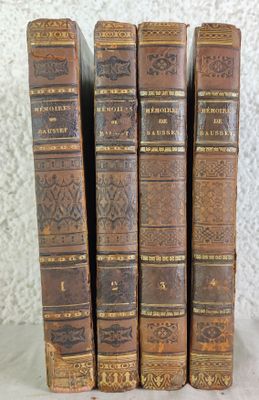 quatre vieux livres sont empilés les uns sur les autres sur une table