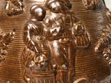 a bronze vase with an image of a man and a woman