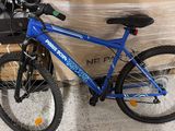 a blue bicycle that is sitting in front of a box