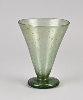 a green glass vase sitting on top of a table