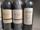 four bottles of wine are lined up on a table
