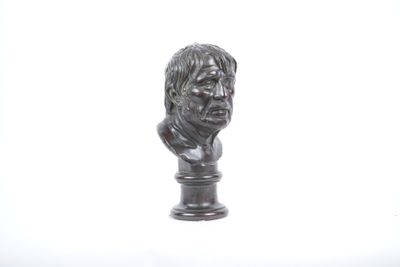 statue représentant le buste d'un homme sur un socle, sur fond blanc