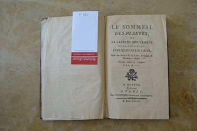 un livre ouvert posé sur une table, à côté d'une étiquette blanche