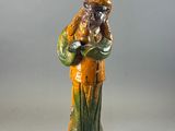 figurine of a man with a beard and a hat holding a bag