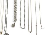 many different types of necklaces on a white surface