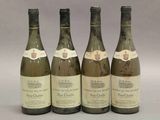 quatre bouteilles de vin sont alignées sur une table
