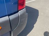 someone is taking a picture of the rear end of a blue van