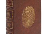 un vieux livre orné d'un emblème doré sur la couverture