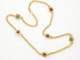 a gold chain with multi colored stones on it