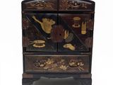 une commode noire et dorée sur fond blanc