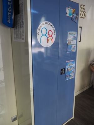 un réfrigérateur bleu recouvert d'autocollants, dans un coin de la pièce