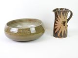 bowl and pitcher sitting next to each other on a white surface