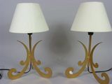 pair of brass table lamps with white lampshads on each of them