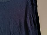 the back of a blue shirt hanging on a hanger on a wall