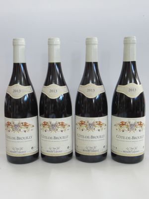 four bottles of wine are lined up on a white surface
