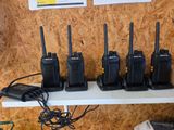 Plusieurs talkies-walkies sont alignés sur une étagère dans une pièce