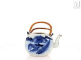 a blue and white teapot with a handle on a white surface