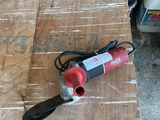 a red and black power tool on a wooden table