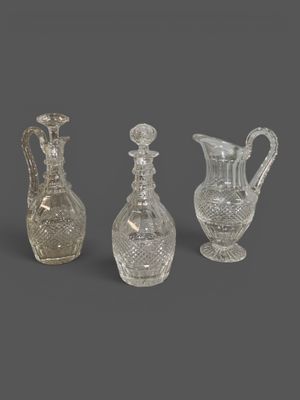 three cut glass vases and a decanter on a grey background