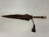 un parapluie marron orné d'un pompon