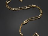 a gold and pearl necklace, by person