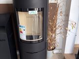 a black stove sitting next to a black trash can